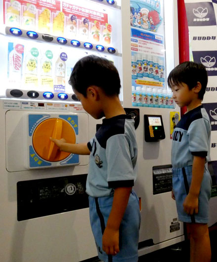 A young child experiences the gacha-gacha function by turning the dedicated handle A young child experiences the gacha-gacha function by turning the dedicated handle